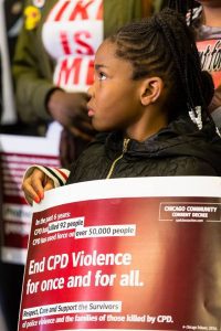Little girl holding sign to end CPD violence