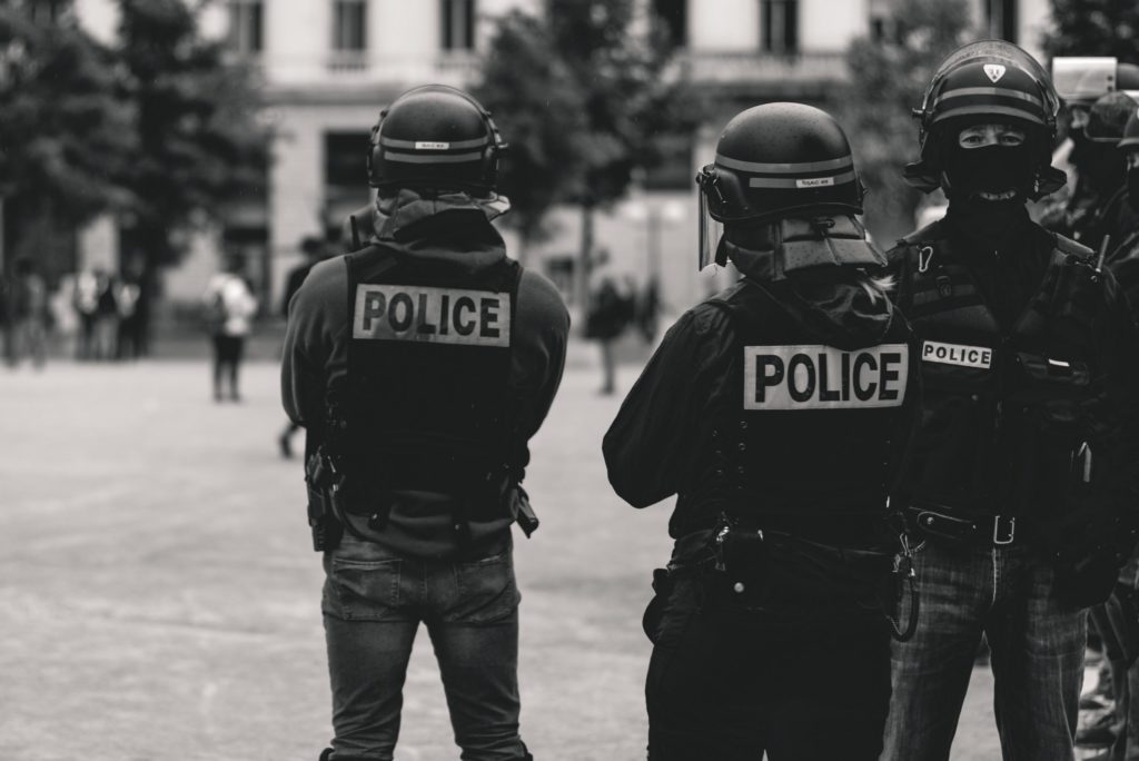 black and white image of police officers in riot gear