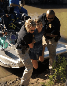 A distressed person being dragged out of a boat by two police officers