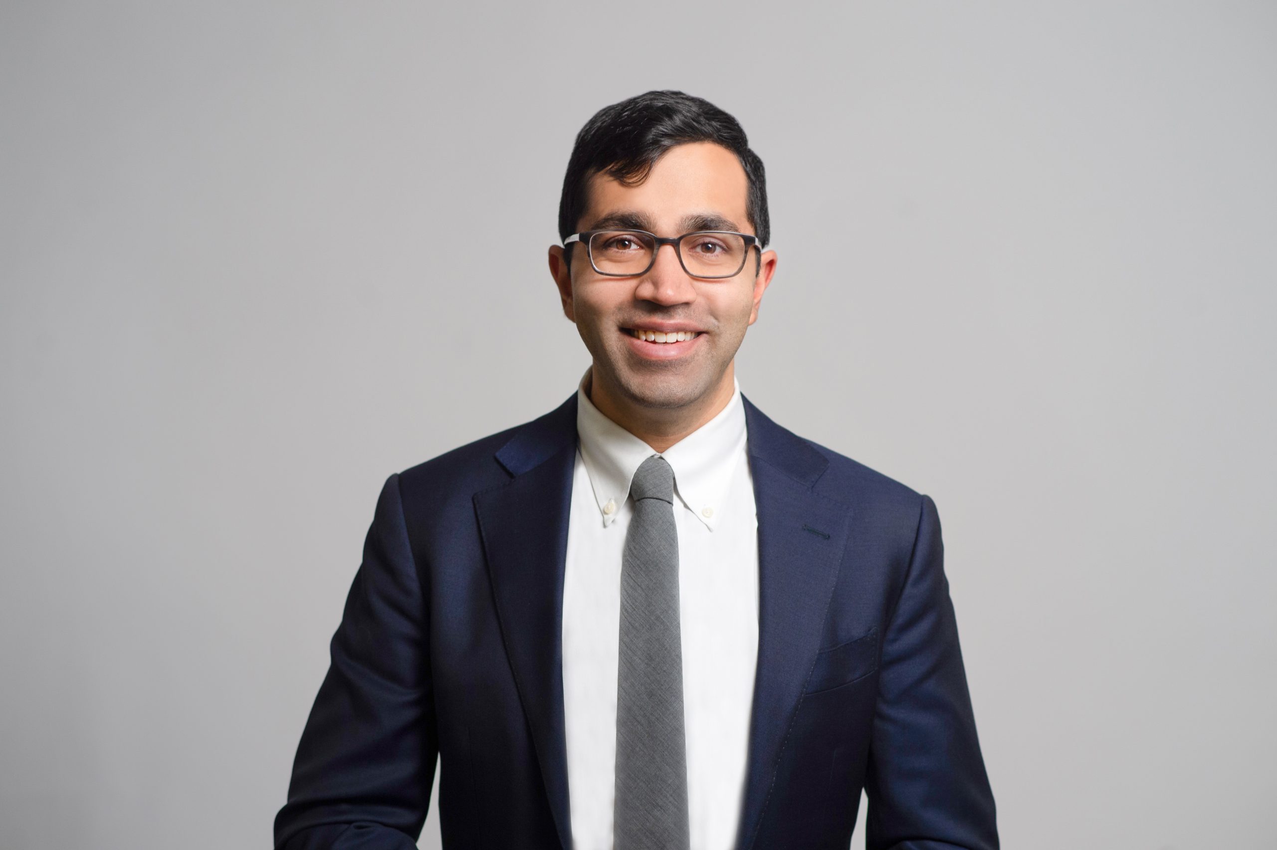 Photo of Amit Jain in blue suit with white shirt and grey tie